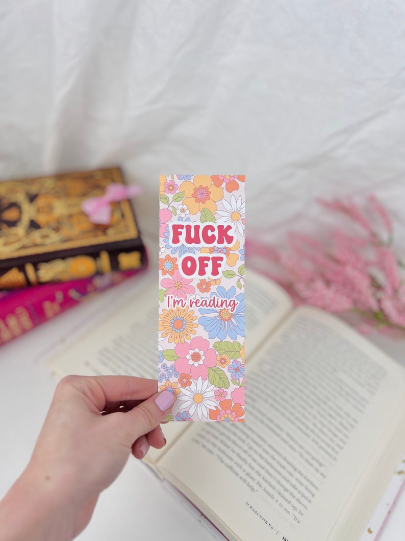 May include: A pink, blue, and yellow floral bookmark with the text "F**k Off I'm reading".