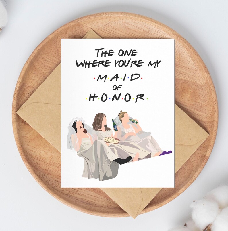 Może przedstawiać: Biała kartka z tekstem "The One Where You're My Maid of Honor" w kolorze czarnym. Na kartce znajduje się kresk&oacute;wkowa ilustracja trzech kobiet w białych sukienkach, trzymających napoje i pizzę.