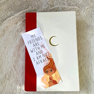 Puede incluir: Un libro blanco con una encuadernaci&oacute;n roja y un marcap&aacute;ginas con un personaje de dibujos animados y el texto "Mis amigos est&aacute;n conmigo y no tengo miedo".