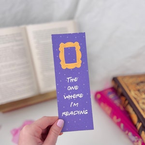 May include: Purple bookmark with a yellow frame and the text "THE ONE WHERE I'M READING".