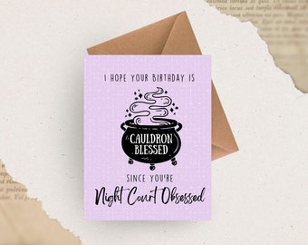 May include: A purple card with a black cauldron and steam coming out of it. The text on the card reads "I hope your birthday is cauldron blessed since you're Night Court obsessed."