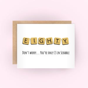 May include: A white card with a brown envelope. The card has the word "EIGHTY" spelled out using Scrabble tiles. The text below the tiles reads "Don't worry... you're only 13 in Scrabble."