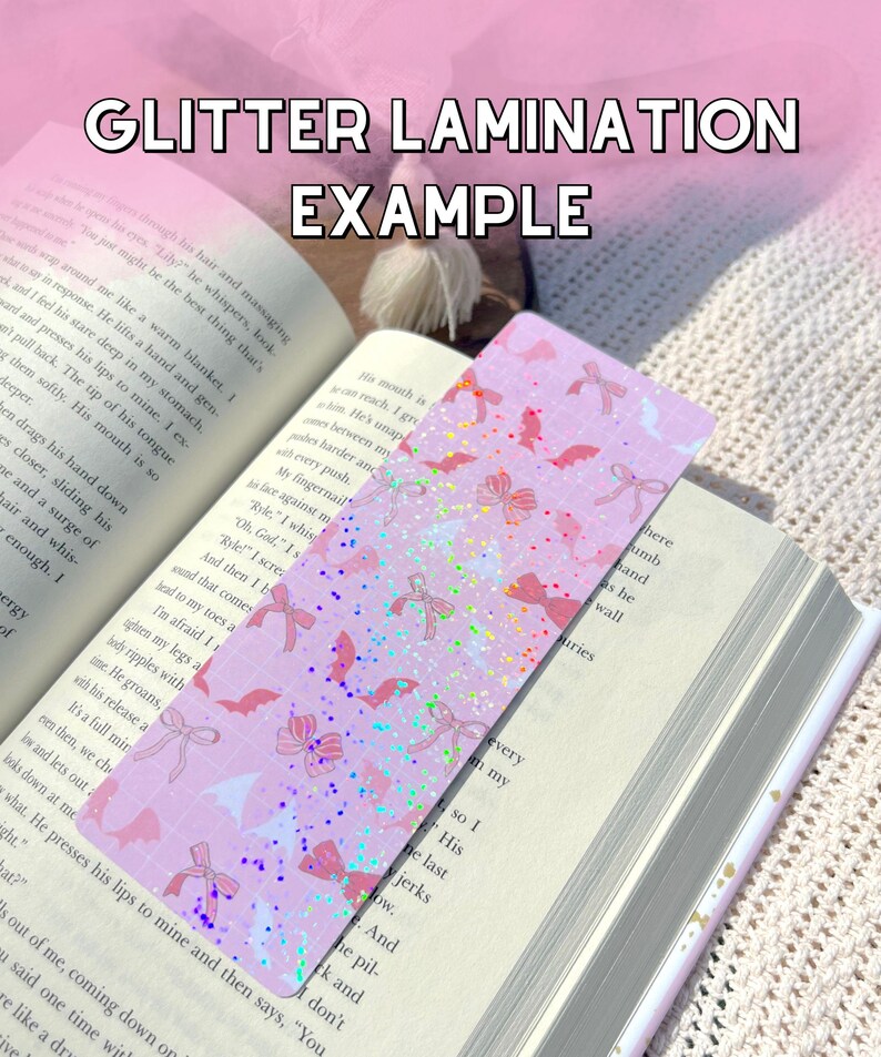 K&ouml;nnte beinhalten: Ein rosa-wei&szlig;es Lesezeichen mit Glitzer-Finish. Das Lesezeichen zeigt ein sich wiederholendes Muster aus Flederm&auml;usen und Schleifen. Der Text "GLITTER LAMINATION EXAMPLE" ist oben im Bild gedruckt.