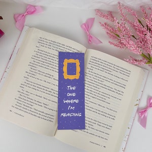 May include: Purple bookmark with a picture of the iconic "Friends" TV show frame and the text "The One Where I'm Reading".