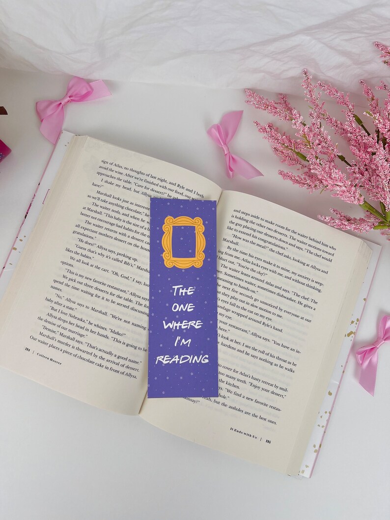 May include: Purple bookmark with a picture of the iconic "Friends" TV show frame and the text "The One Where I'm Reading".