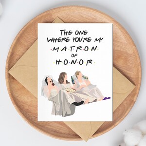 Może przedstawiać: Biała kartka z tekstem "The One Where You're My Matron of Honor" w kolorze czarnym i ż&oacute;łtym. Na kartce znajduje się kresk&oacute;wkowa ilustracja trzech kobiet w białych sukienkach i welonach, siedzących na kanapie i oglądających telewizję.
