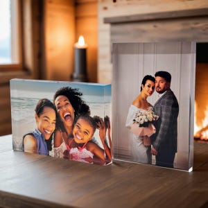 May include: Two acrylic photo blocks with different images. The first block shows a family of three women smiling at the camera on a beach. The second block shows a couple in formal attire, the woman holding a bouquet of flowers.