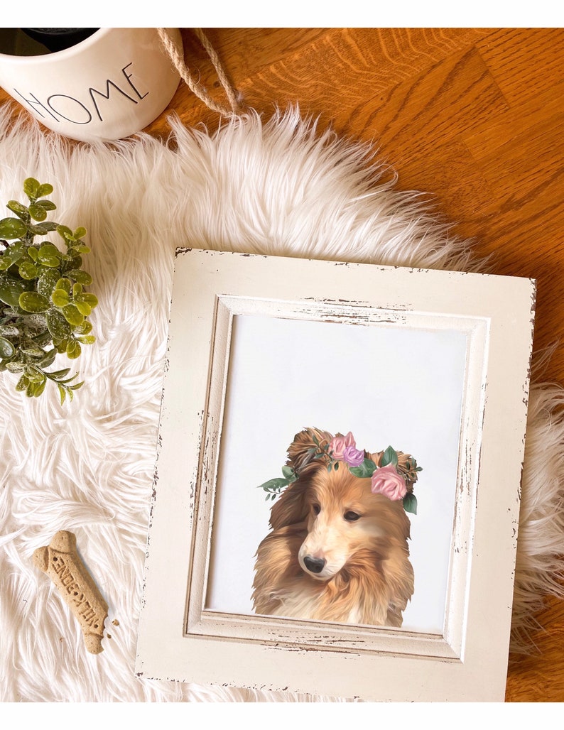 May include: A framed print of a dog wearing a flower crown. The dog is a brown and white Collie with a white background. The frame is white with a distressed look.