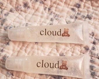 May include: Two clear lip gloss tubes with a white label that says "cloud" and a small cartoon bear image.