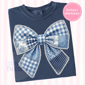 May include: A navy blue t-shirt featuring a large bow design. The bow is made of various blue patterned fabrics, including gingham, floral, and lace, and is outlined with faux pearls. The words "instant download" are in a pink circle.