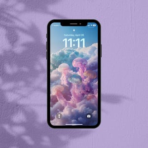 May include: A black smartphone displays a jellyfish wallpaper against a purple background. The screen shows the date as Saturday, April 26, and the time as 11:11. The jellyfish are pink, purple, and white, set against a cloudy sky.