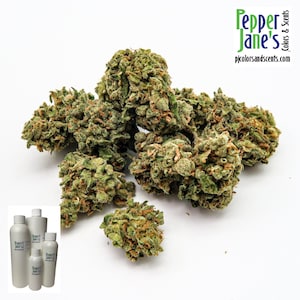 May include: Close-up of several green and brown cannabis buds. The image also includes a logo that says "Pepper Jane's Colors & Scents" and the website address "pjcolorsandscents.com". There are also several white bottles in the lower left corner.