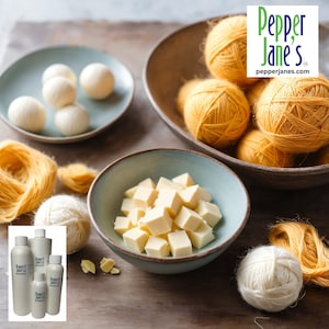 May include: A still-life arrangement featuring various craft supplies. Bowls hold white yarn balls, yellow yarn skeins, and cubed wax. Several bottles are also present, with the Pepper Jane's logo. The scene is set on a wooden surface.