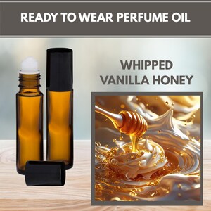 May include: Two amber glass roll-on perfume oil bottles with black caps. One bottle has a white rollerball top. The text reads "READY TO WEAR PERFUME OIL" and "WHIPPED VANILLA HONEY". An illustration shows honey dripping from a dipper.