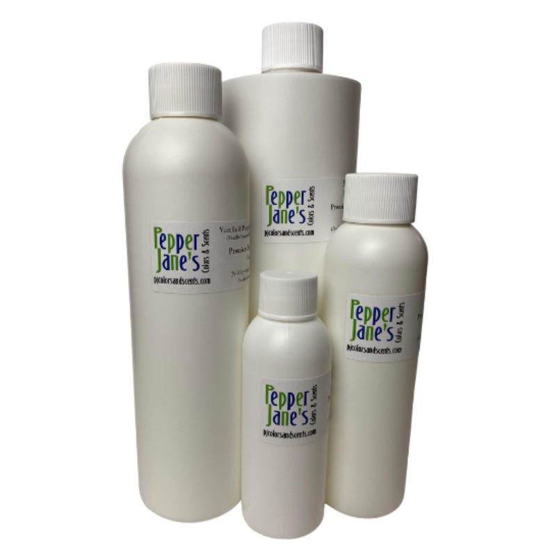 May include: A collection of white plastic bottles with white screw-on caps. Each bottle has a label with the text "Pepper Jane's" in green and the website address. The bottles vary in size, suggesting different product volumes.