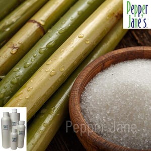 May include: Close-up of sugarcane stalks with water droplets, a wooden bowl filled with white granulated sugar, and several white bottles. The image includes the text "Pepper Jane's".