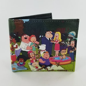 May include: Bi-fold wallet featuring a colorful cartoon scene of various characters at a picnic. The wallet is black on the inside and has a printed design on the outside. The characters are in a park setting.