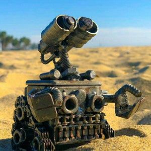 Statuetka z recyklingowanego metalu inspirowana Wall-E, otwierana do góry, inspirowana kreskówką. Wykonana ręcznie i spawana ręcznie z nakrętek, śrub, łańcuchów, blachy i różnych elementów