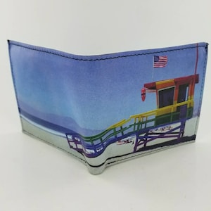 Könnte beinhalten: Eine blaue und weiße dreifach gefaltete Brieftasche mit einem bunten Rettungsschwimmerstand und einer amerikanischen Flagge auf der Vorderseite.