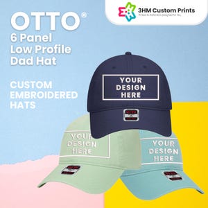 May include: Three low-profile dad hats in navy blue, mint green, and light blue. Each hat features a white rectangle with the text "YOUR DESIGN HERE." The hats are embroidered and branded with "OTTO."