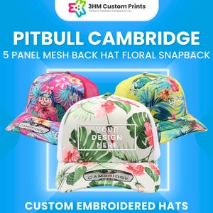 May include: Three floral snapback hats with mesh backs are displayed against a blue background. The hats feature vibrant floral patterns in pink, yellow, and white. Text on the hats includes "PITBULL CAMBRIDGE" and "YOUR DESIGN HERE". The image also includes the text "CUSTOM EMBROIDERED HATS".
