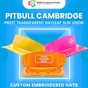 May include: Three colorful sun visors: yellow, pink, and orange. The visors have a transparent bayleaf design and the text "YOUR DESIGN HERE" on the orange visor. The image also includes the text "PITBULL CAMBRIDGE" and "CUSTOM EMBROIDERED HATS".