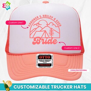 K&ouml;nnte beinhalten: Coralfarbene, wei&szlig;e und korallenfarbene Trucker-Kappe mit einer rosafarbenen Bergszene und dem Text "GARDNER & HAILEY 4 EVER" und "Bride". Die Kappe ist mit zwei Textzeilen anpassbar.