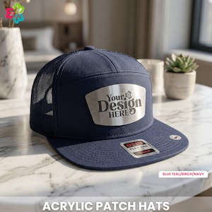 May include: A navy blue acrylic patch hat with a mesh back and a flat brim. The hat features a silver patch with the text "Your Design Here." The bottom of the hat has a small sticker that says "OTTO FLEX BILL SNAP." The text "ACRYLIC PATCH HATS" is at the bottom.