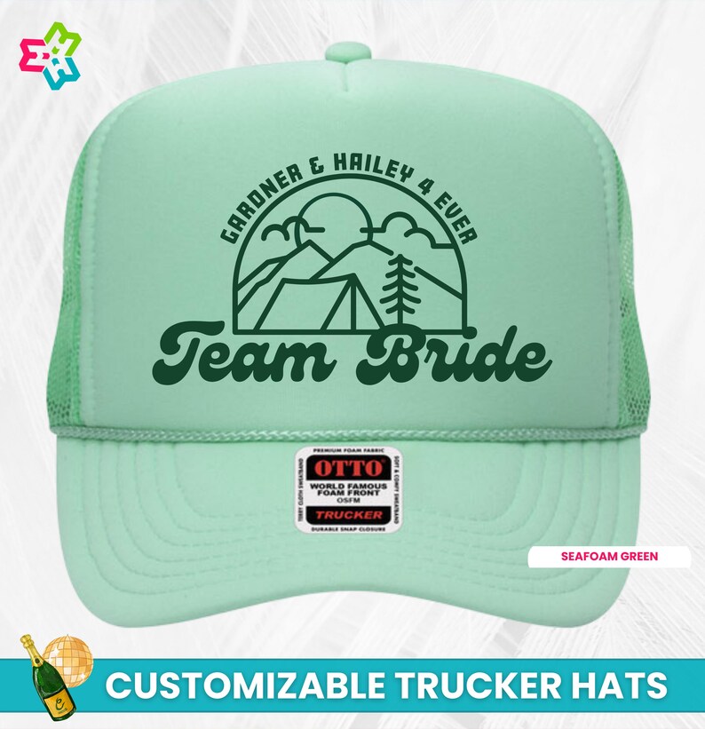 K&ouml;nnte beinhalten: Trucker-Kappe in Seefraben-Gr&uuml;n mit einer gr&uuml;nen Bergszene und dem Text "GARDNER & HAILEY 4 EVER Team Bride". Die Kappe hat ein schwarzes Netzr&uuml;cken und einen schwarzen Druckknopfverschluss.