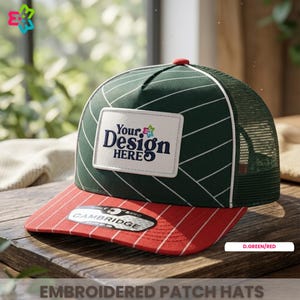 May include: Green and red embroidered patch hat with the text "Your Design HERE" on a white patch. The hat has a red brim with white stripes and a mesh back. The hat is labeled "CAMBRIDGE".