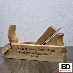 Peut inclure: Un rabot à main en bois avec une citation de Mark Twain gravée sur le côté : « L'homme qui a une nouvelle idée est un fou jusqu'à ce que cette idée réussisse. »