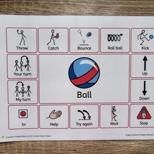 May include: A printed sheet with a grid of illustrated action icons, including "Throw," "Catch," and "Kick." A large blue and red ball graphic is centered, with the word "Ball" below. Other icons include "Up," "Down," and "Stop."