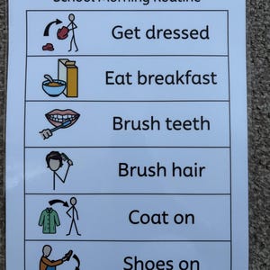 May include: A printed chart titled "School Morning Routine" with six illustrated steps: Get dressed, Eat breakfast, Brush teeth, Brush hair, Coat on, and Shoes on. The chart is white with black text and icons, and is on a textured surface.
