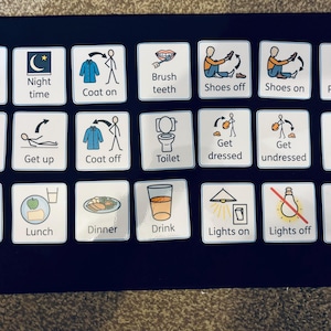 May include: A collection of 20 white square cards featuring blue and black text and illustrations. The cards illustrate daily routines, including "Daytime", "Night time", "Coat on", "Brush teeth", "Shoes off", "Shoes on", "Pyjamas", "Home", "Get up", "Coat off", "Toilet", "Get dressed", "Get undressed", "Wash hands", "Breakfast", "Lunch", "Dinner", "Drink", "Lights on", "Lights off", and "Bedtime".