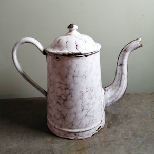 Op de afbeelding: Witte emaille theepot met een gekrakelde glazuur. De theepot heeft een handvat en een tuit.