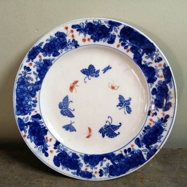 Assiette antique en faïence de fer et étain émaillée à décor de papillons bleu flux et rouge fer