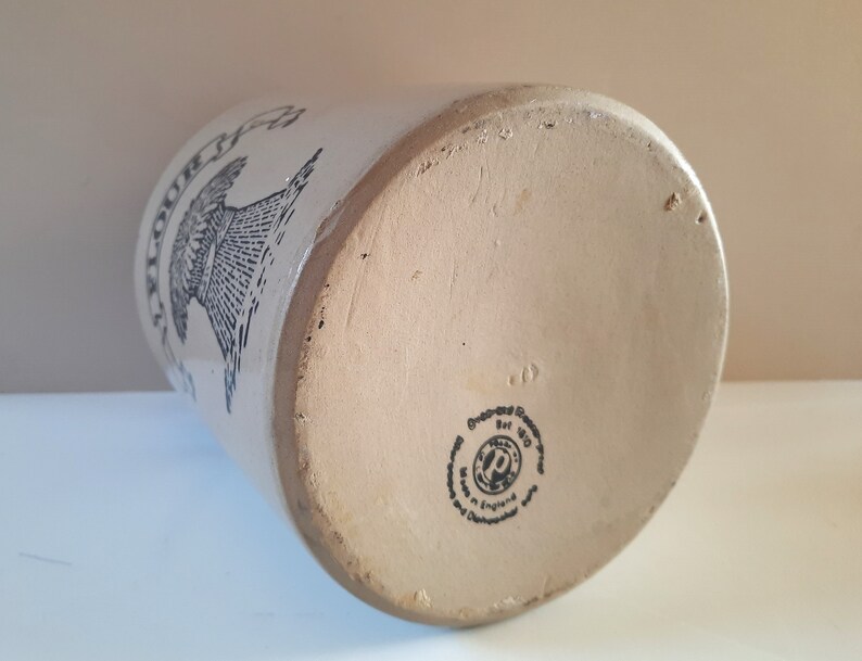 Peut inclure: Un pot en c&eacute;ramique blanche avec une image en noir et blanc d'un moulin &agrave; vent et le texte "Anchor" sur le c&ocirc;t&eacute;. Le fond du pot porte un tampon noir qui indique "Regd. Des. 871190 Made in England".