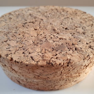 Peut inclure: Un bouchon de li&egrave;ge rond et brun avec une surface rugueuse et textur&eacute;e.