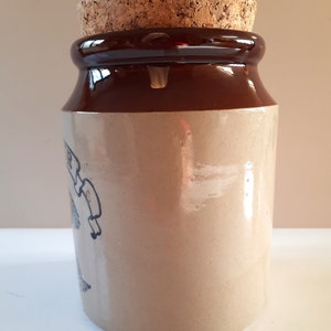 Peut inclure: Un pot en gr&egrave;s brun et beige avec un couvercle en li&egrave;ge. Le pot est recouvert d'un gla&ccedil;age brun sur le dessus et le dessous et d'un gla&ccedil;age beige sur le corps. Le pot a un design simple avec une petite image d&eacute;lav&eacute;e sur le c&ocirc;t&eacute;.
