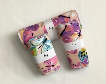 May include: Three rolled fabric pieces with a butterfly and floral pattern in pink, purple, and blue. The sizes are labeled as 8x8 inches, 8x5 inches, and 6x6 inches. The fabric has a white border.