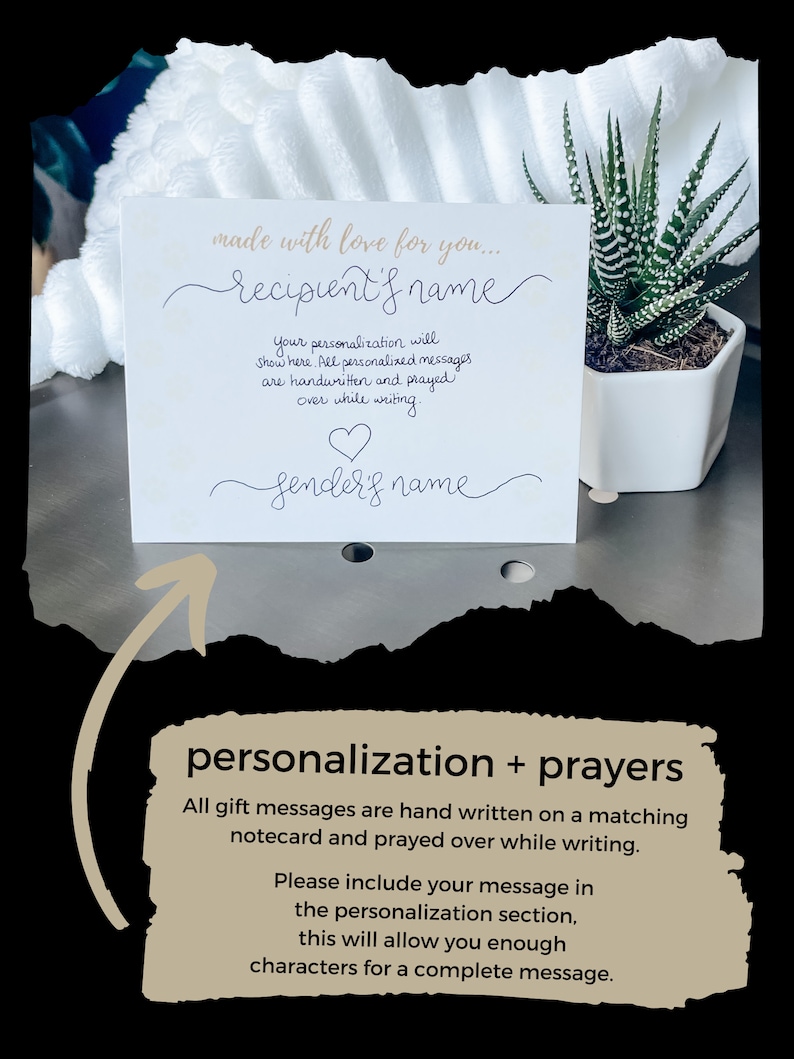 May include: A white card with the text "made with love for you..." and a space for the recipient's name. The card also includes a space for the sender's name and a heart symbol. The text "Your personalization will show here. All personalized messages are handwritten and prayed over while writing." is also included on the card. The card is sitting on a white surface with a small potted plant in the background.