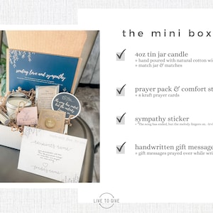 K&ouml;nnte beinhalten: Eine wei&szlig;e Geschenkbox gef&uuml;llt mit Mitgef&uuml;hlsartikeln, darunter eine kleine Kerze, ein Troststein und Gebetskarten. Die Box ist mit einer blauen und wei&szlig;en Karte verziert, auf der "sending love and sympathy" steht.