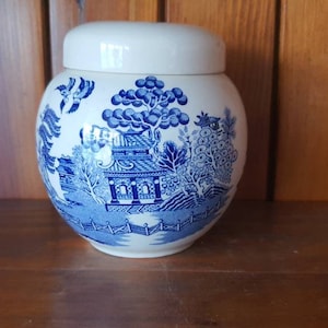 May include: A white ceramic jar with a blue and white floral design. The jar has a lid and is decorated with a traditional Chinese pattern.