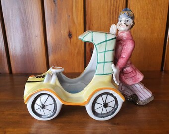 Vintage Italian made model of a man pushing an old car.