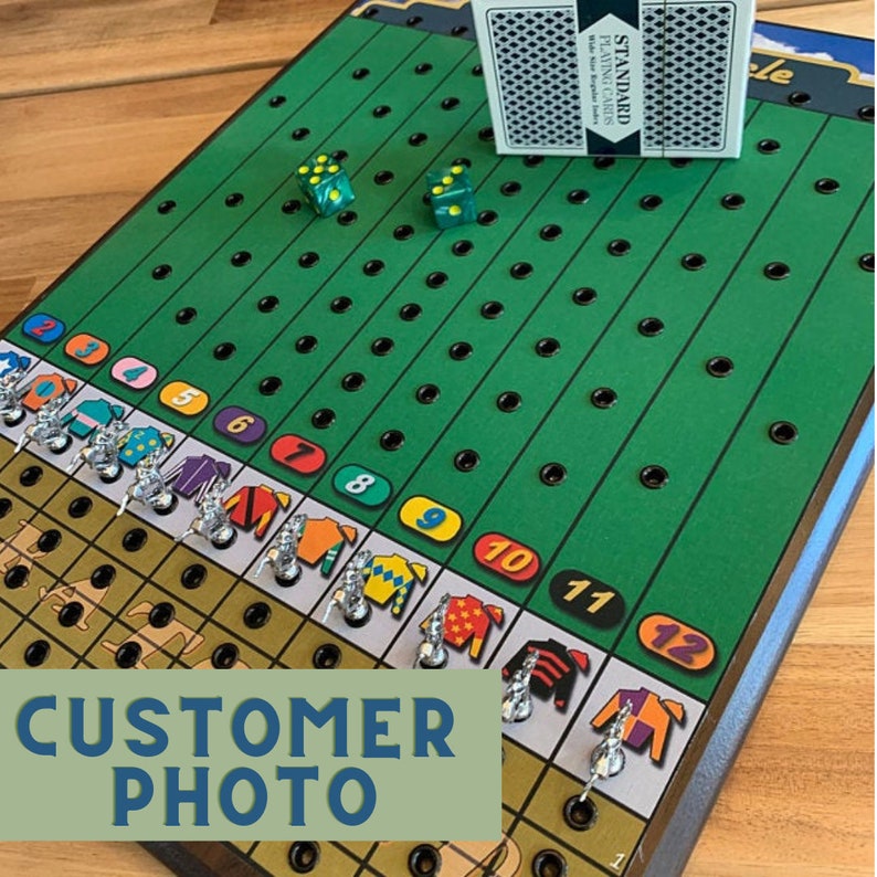 May include: A green and brown game board with a horse racing theme. The board has 12 numbered spaces and a set of dice. The board is made of wood and has a green felt surface. The game is called "Le"