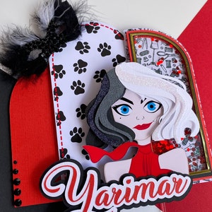 Könnte beinhalten: Ein roter, weißer und schwarzer Tortendekor mit einem Cartoon-Bild von Cruella de Vil aus dem Disney-Film 101 Dalmatiner. Der Dekor enthält eine rote Schleife, schwarz-weißes Haar und ein rotes Kleid. Der Name "Yarimar" ist in roten und weißen Buchstaben auf der Unterseite des Dekors geschrieben.