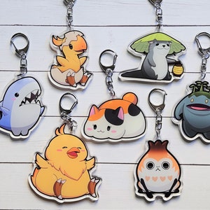 May include: A set of eight colorful acrylic keychains featuring various cartoon animal characters. The characters include a shark, a chick, a cat, a bird, a otter, a dinosaur, a mushroom creature, and a plant creature.