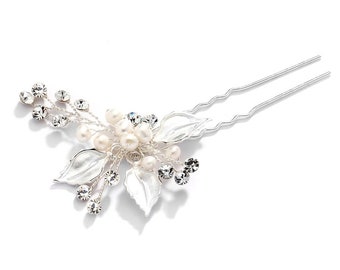Puede incluir: Peine de pelo plateado con un racimo de perlas falsas y diamantes de imitación en un diseño floral.