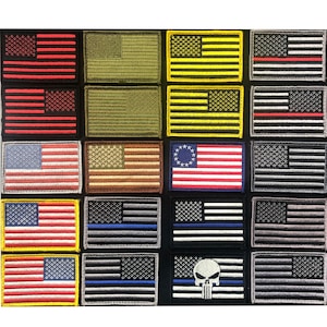 May include: A collection of twenty rectangular embroidered patches featuring various American flag designs. The patches include monochromatic, multi-colored, and black and white versions, with one patch displaying a skull graphic and another a circular star pattern.