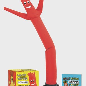 May include: A red inflatable tube man with a smiling face and outstretched arms. The tube man is attached to a black base. The image also shows a box and a book with the text "Wacky Waving Inflatable Tube Guy".